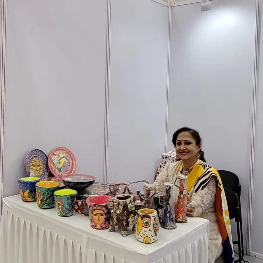 The festival stall, its table set with wall plates, bowls and hand-painted planters.